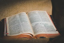 an open Bible on a couch 