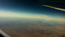 Timelapse of earth below as seen from an airplane window.