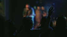 Audience worshipping as a band plays a concert.