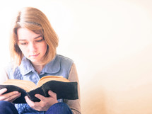 a young woman reading a Bible 