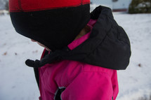 a little girl in a snowsuit and winter coat 