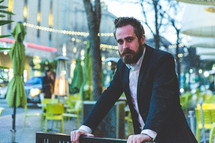 man in a blazer near an outdoor cafe 