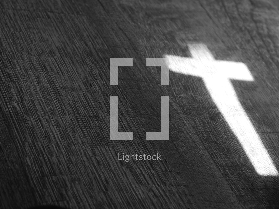 light in the shape of a cross on wood 