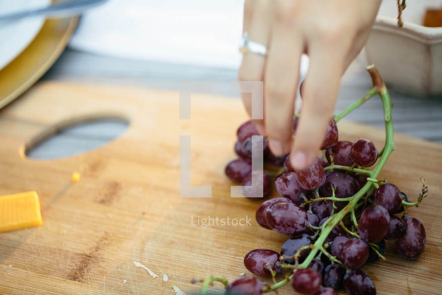 hand reaching for grapes 