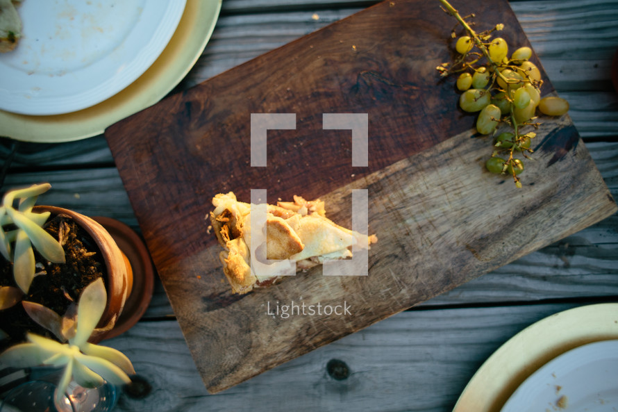 slice of pie and grapes on a wood plater 
