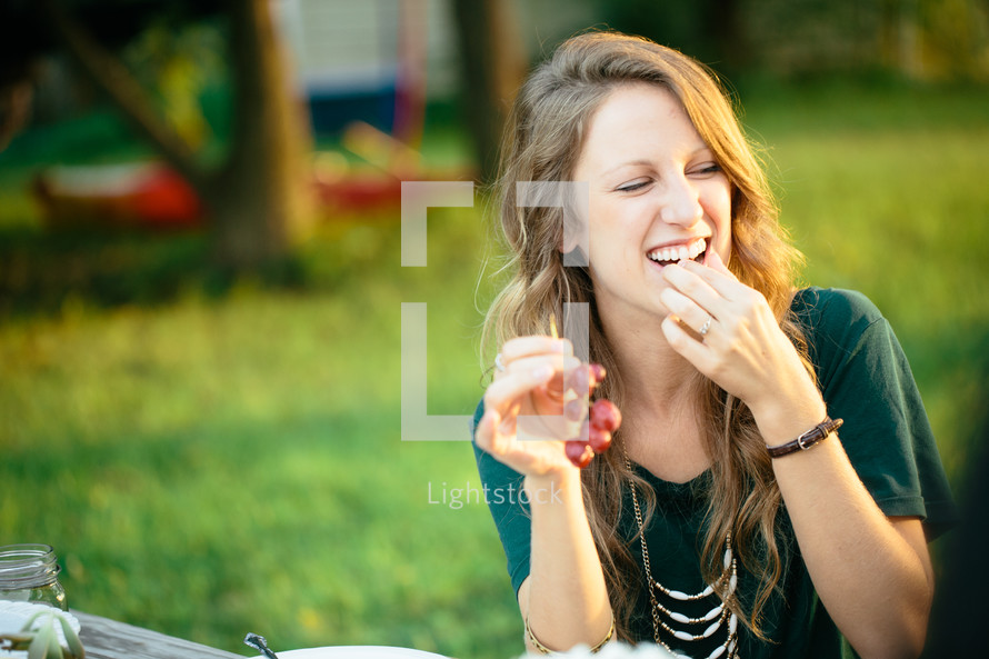 a woman eating grapes 