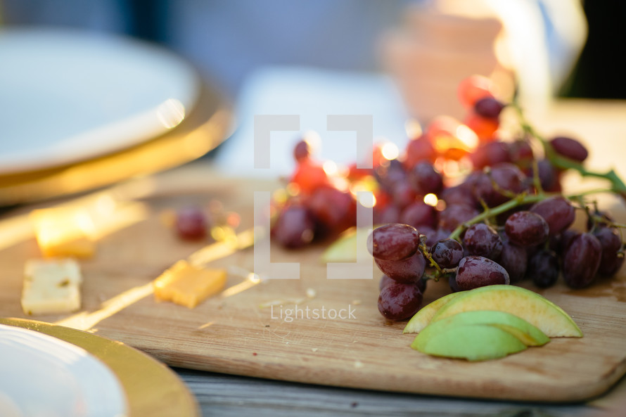 grapes and apple slices on a cutting board