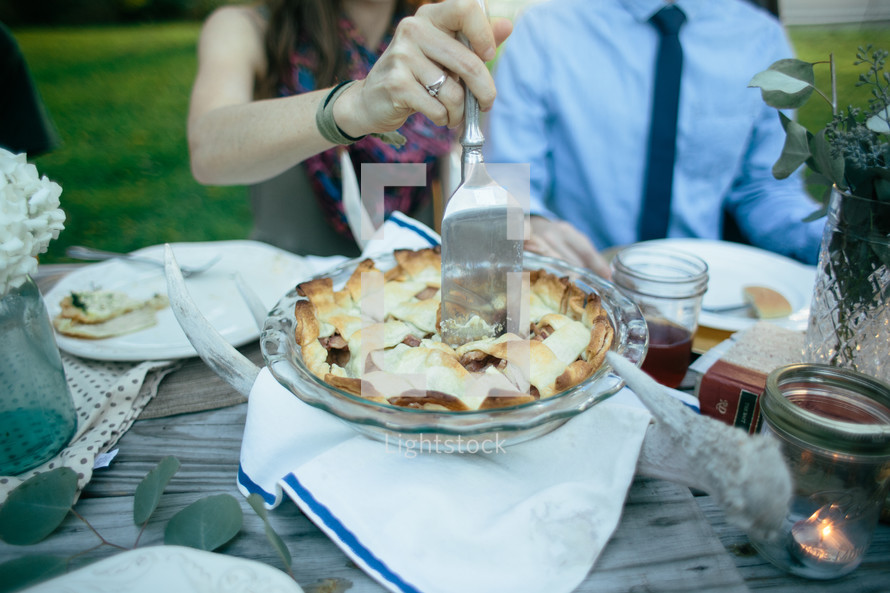 cutting a pie at a table 