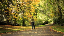 woman walking on a park path in autumn 