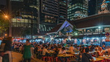 busy outdoor seating area at a Restaurant in Singapore at night 