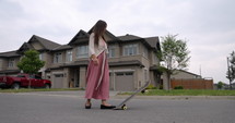 Female South American Latina skateboarder cruising around neighbourhood on skateboard - dynamic follow shot