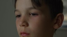 Young boy looking around with worried nervous look on face - extreme close up on face - rack focus