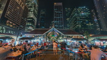 busy outdoor seating area at a restaurant Singapore at night 
