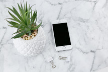houseplant, cellphone, clips on marble 