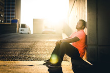 a man sitting on a curb waiting 