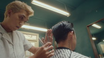 Asian Barber Trimming the Ends of the Hair of Client