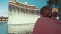 a woman watching the Bellagio fountains 