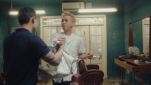 Cheerful Asian Barber Greeting Customers at the Barbershop