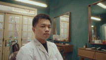 Young Asian Barber at Work in Retro Styled Hairdressing Salon