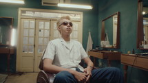 Cool Asian Barber Posing for Camera in Vintage Barbershop
