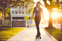 a young woman skating on a skateboard down a sidewalk 