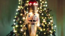 Nutcracker puppet talking against the Christmas tree
