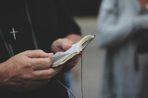man reading a pocket Bible 