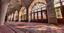 colorful light from stained glass windows on carpets in a mosque 