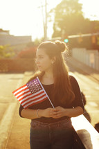 a young woman holding an American flag 