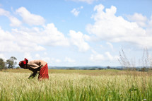 Woman picking wheat in a field