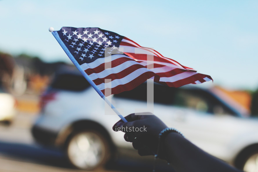 waving an American flag during a parade 