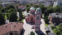 Aerial: the Holy Trinity Church in Banja Luka surrounded by lush trees, Bosnia