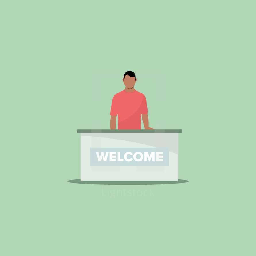 man behind a desk with a welcome sign 
