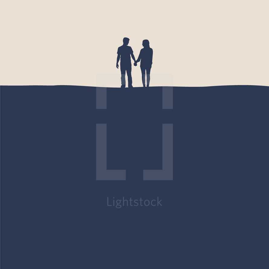 silhouette of a couple holding hands on a hill 