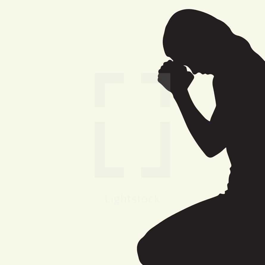 woman with head bowed praying.