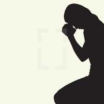 woman with head bowed praying.