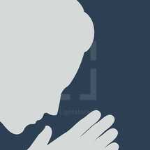 silhouette of a man with head bowed and praying hands 