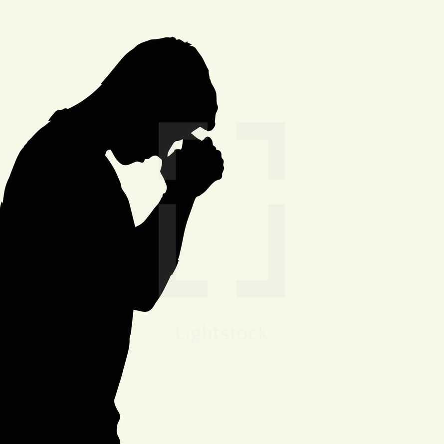 man with head bowed praying 